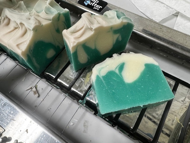 Green and white soap bars on a metal surface