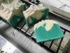 Green and white soap bars on a metal surface