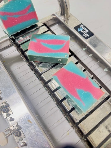 Colorful cotton candy soap bars on a professional cutter. 