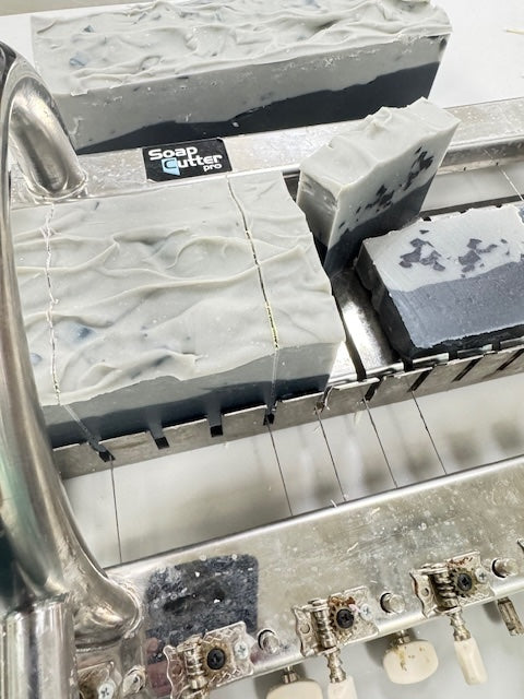 Soap cutting machine with soap bars and a 'Soap Gutter' label.