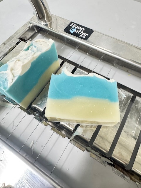Two layered soap bars on a metal soap cutter with 'Soap Lifter Pro' branding.